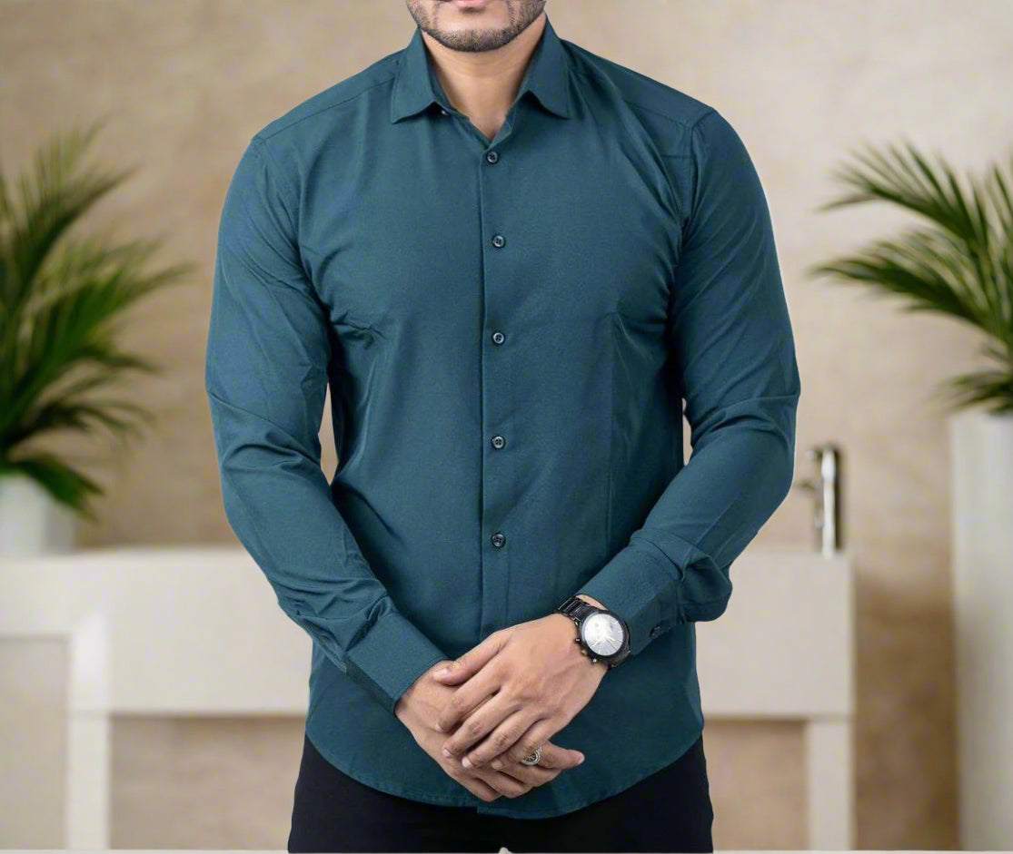 Man wearing a teal button-up shirt on a light gray background