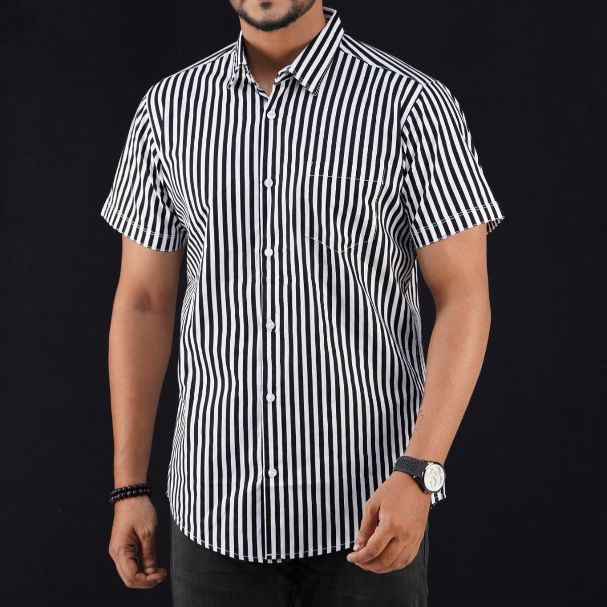 Man wearing a black and white striped shirt against a black background