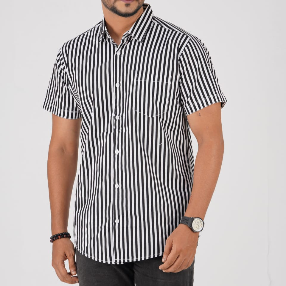 Man wearing a black and white striped shirt on a plain background